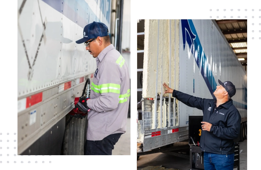 A man in a blue jacket is working on the side of a truck.