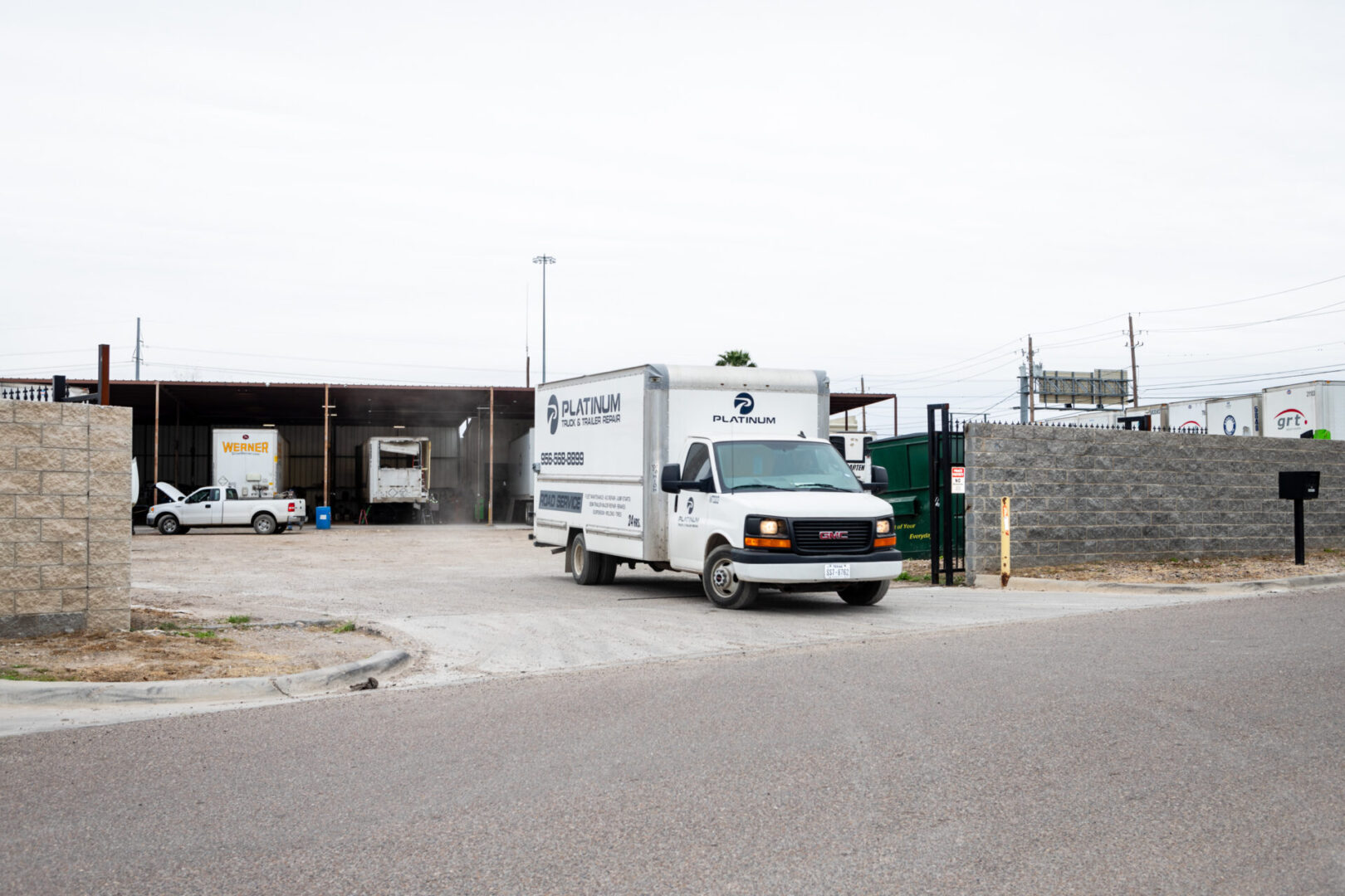 A white truck parked in front of a building.